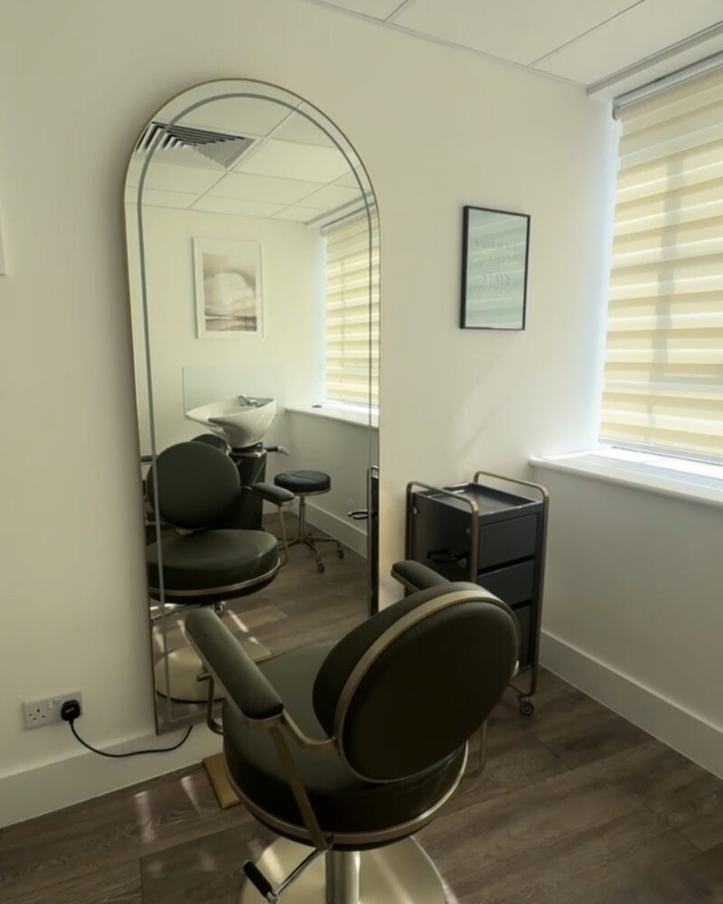 The studio: the full arched mirror, chair and basin in daylight.